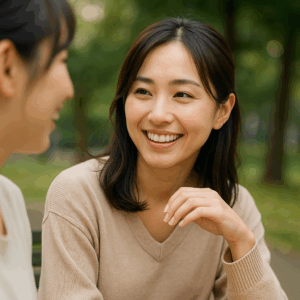 友人と談笑しながらも気配りを見せる日本人女性。自然な笑顔と落ち着いた仕草。
